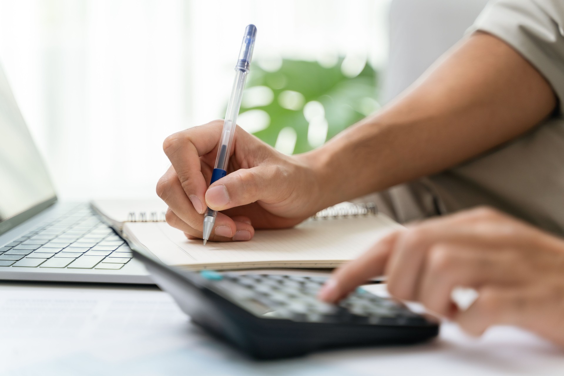 Man is calculating annual tax with calculator and filling form of Individual Income Tax Return. Season to pay Tax and Budget planning concept.